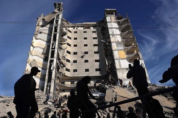 Palestinos frente a un edificio residencial alcanzado en un bombardeo israelí en Rafah. 