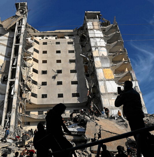 Palestinos frente a un edificio residencial alcanzado en un bombardeo israelí en Rafah.