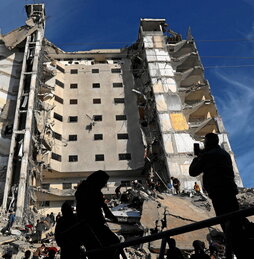 Palestinos frente a un edificio residencial alcanzado en un bombardeo israelí en Rafah.