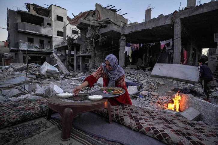 Una palestina prepara la cena que rompe el ayuno entre las ruinas de su casa en Deir el-Balah.