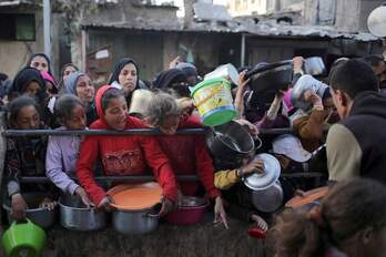 Palestinos desplazados esperando a recoger comida en Rafah, en el primer dia de Ramadán.