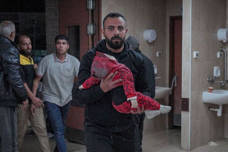  Un hombre lleva a un bebé rescatado de las ruinas de la vivienda de la familia Al-Atrash, en Deir al-Balah.