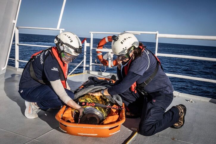 Tripulantes de Ocean Viking asisten a un migrantes rescatado.
