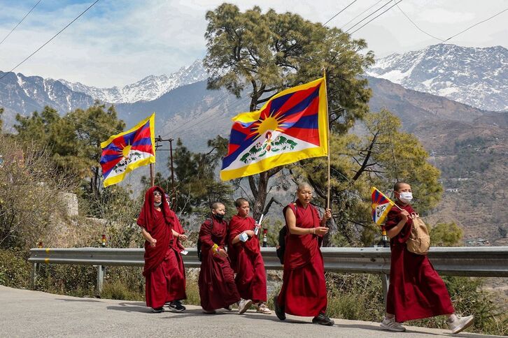 Monjes tibetanos exiliados en India sostienen banderas del Tíbet durante una marcha por la paz en con motivo del 65 aniversario del Alzamiento Tibetano contra la ocupación china, en el suburbio de McLeod Ganj, cerca de Dharamsala, el pasado domingo.