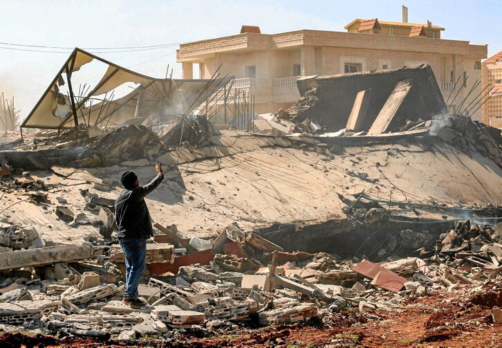 Un hombre gesticula junto a un edificio destruido durante un ataque aéreo nocturno israelí en la ciudad de Baalbek, en el centro-este de Líbano, el 12 de marzo de 2024.