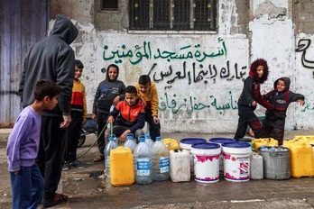 Niños llenan garrafas de agua en Rafah.