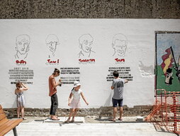 Vecinos en tareas de rehabilitación del mural que recuerda en la plaza Patxa de Baiona a Lasa y Zabala, al igual que a Larre y Anza.