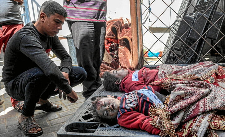 Un familiar llora ante los cuerpos de dos menores tras un bombardeo israelí en Rafah.