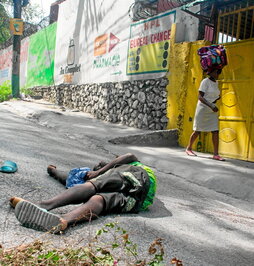 Una mujer pasa por al lado de un cadáver en Puerto Príncipe el pasado 27 de marzo.