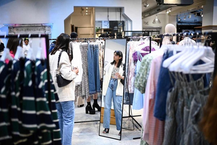 Una mujer observa la ropa a la venta en una tienda de París. 