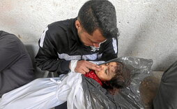 Ashraf sostiene a una de sus dos hijas, ambas muertas ayer en un ataque israelí en Rafah.