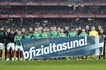 Los jugadores de Euskal Selekzioa, con una pancarta por la oficialidad en el amistoso de San Mamés ante Uruguay.