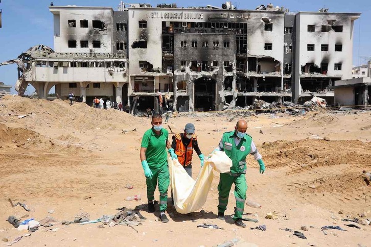  Miembros de Defensa Civil llevan uno de los cuerpos encontrados en el hospital destruido de Al-Shifa.