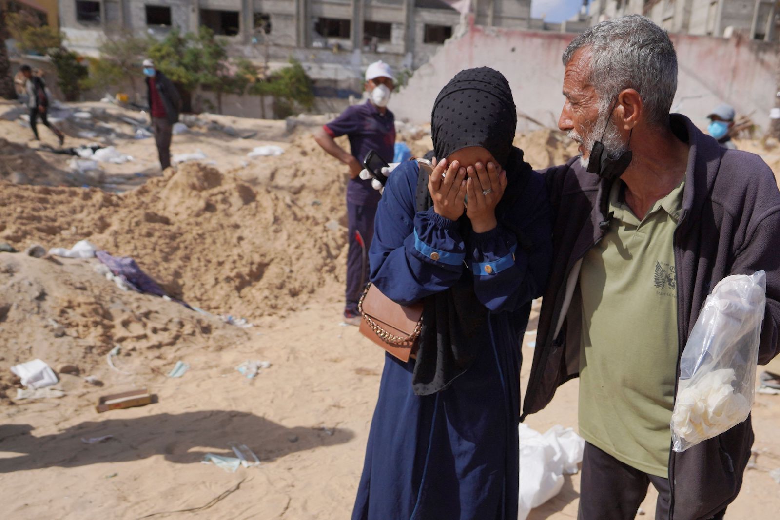 Una mujer llora cerca de la fosa.  (AFP)