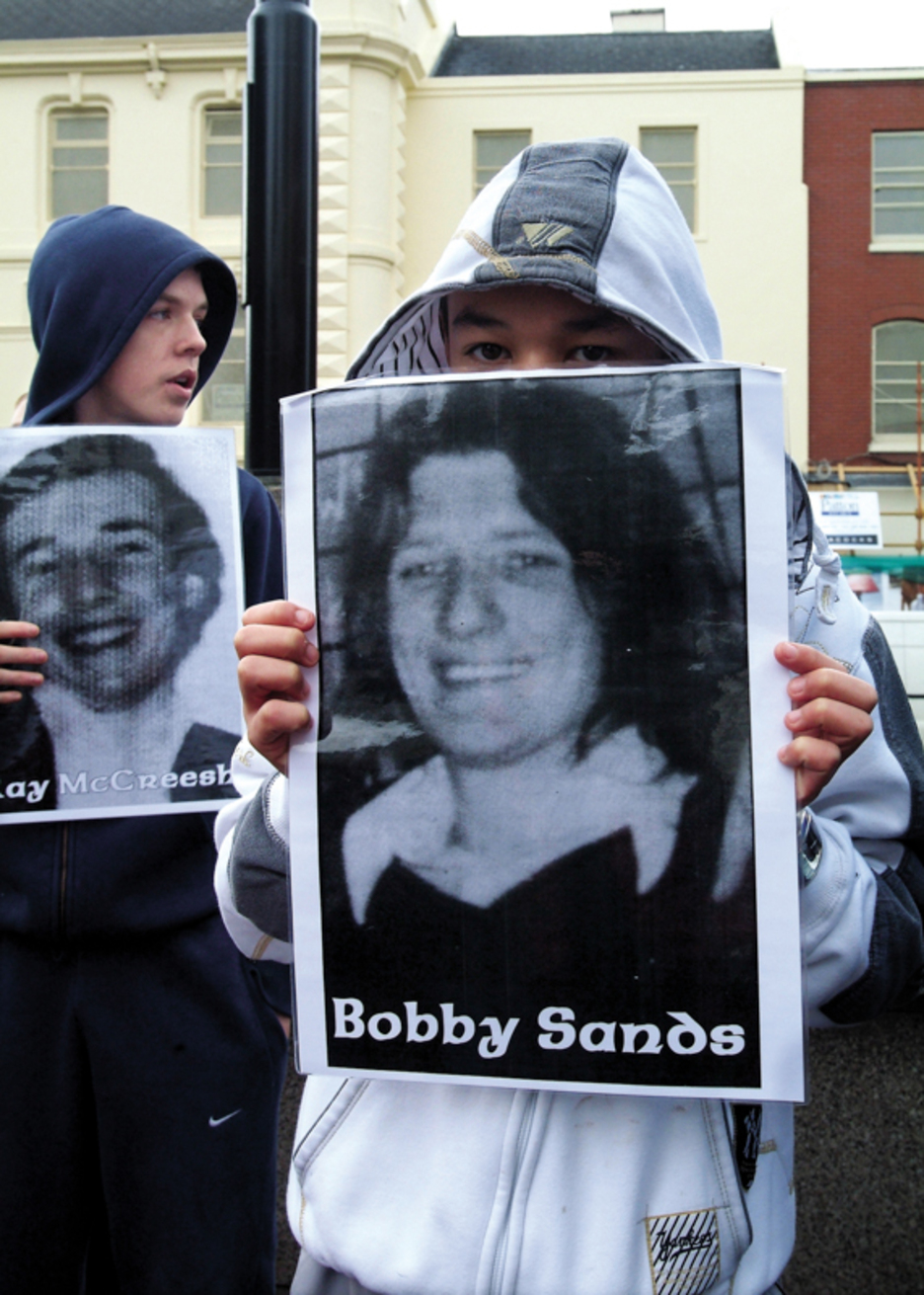 Unos adolescentes exhiben en Belfast imágenes de los huelguistas de hambre en el 25º aniversario, en 2006.