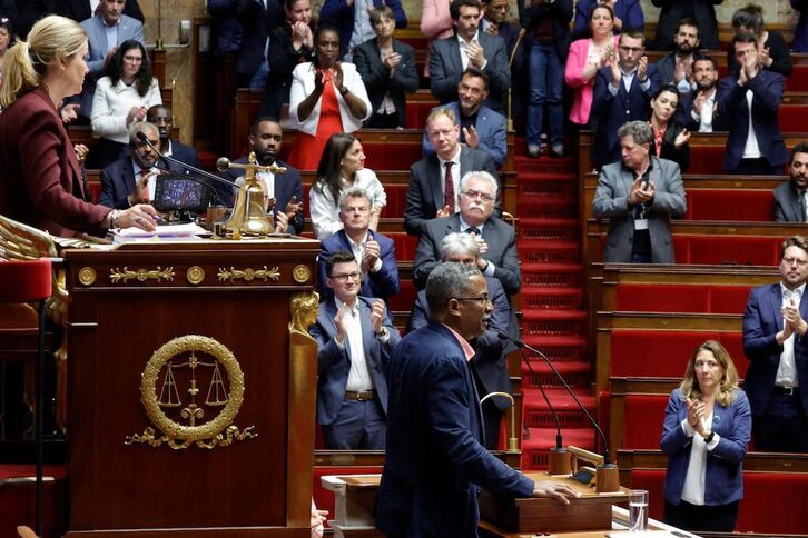 Diputados de la alianza de izquierda Nupes aplauden al electo guyanés, Jean-Victor Castor, durante su intervención, contraria a la desnaturalización del censo electoral kanako.