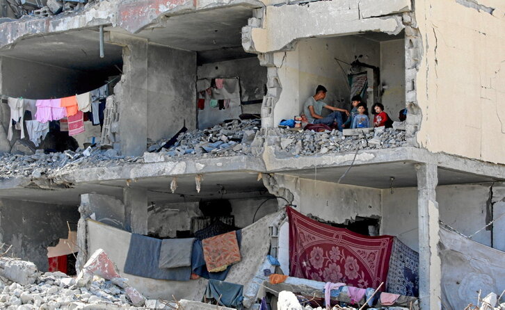 Familias palestinas, viviendo entre las ruinas de una casa destruida por los bombardeos en Rafah.