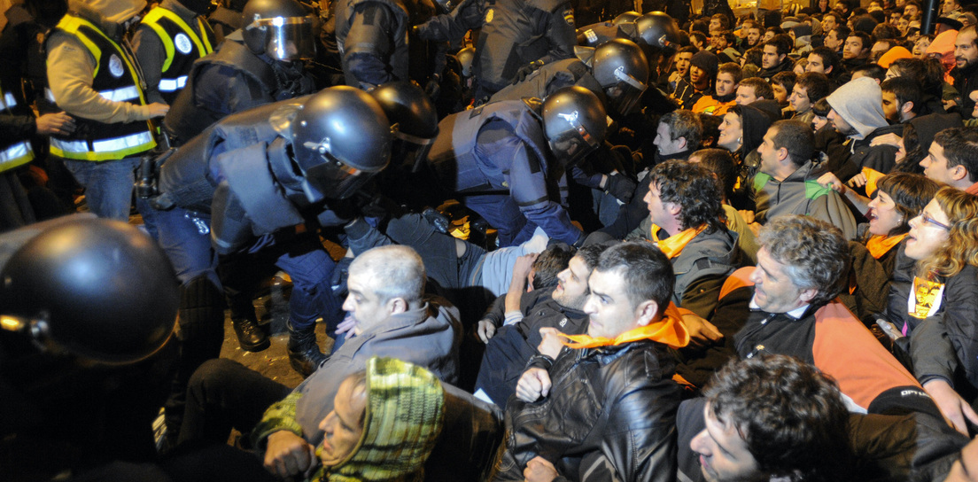 Espainiako Polizia herri harresia desegiten saiatzen Iruñean, auzipetutako gazteetako bat atxilotzeko.
