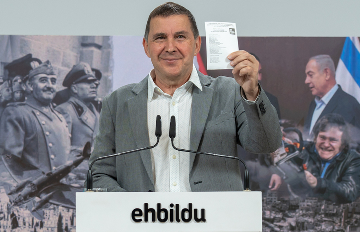 Arnaldo Otegi, con la papeleta de EH Bildu y el cartel que simboliza el fascismo, en la comparecencia de este lunes.