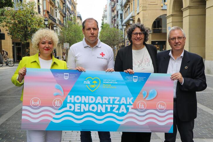 Maite Peña, Felix Zubiria, Alicia Figueroa y José Ignacio Asensio, con el cartel de "Hondartzak Denontzako" en la Plaza Gipuzkoa