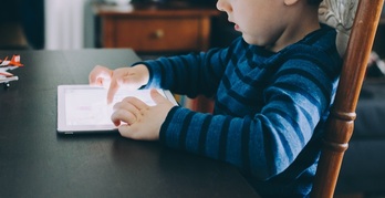 Un menor juega con una tablet, en una imagen de archivo.