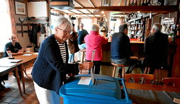 Una mujer deposita su voto en un bar habilitado como colegio electoral en Países Bajos.