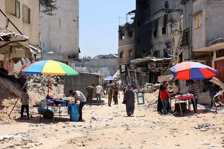 Dos puestos de vendedores de Gaza, entre las ruinas del edificio devido al conflicto con Israel