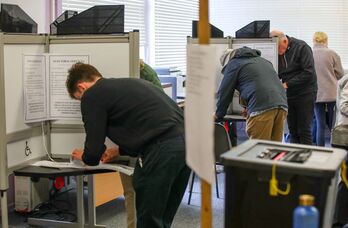 Votantes marcan sus papeletas mientras votan en un colegio electoral de Dublin.