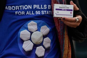 Una manifestante a favor del aborto con una caja de mifepristona, la píldora abortiva.