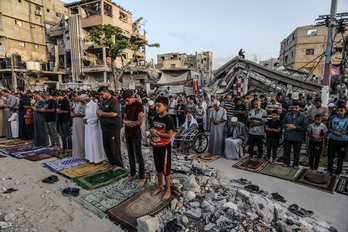 Los palestinos realizan la oración de Eid al-Adha junto a casas destruidas por aviones de combate israelíes en la ciudad de Khan Yunis.