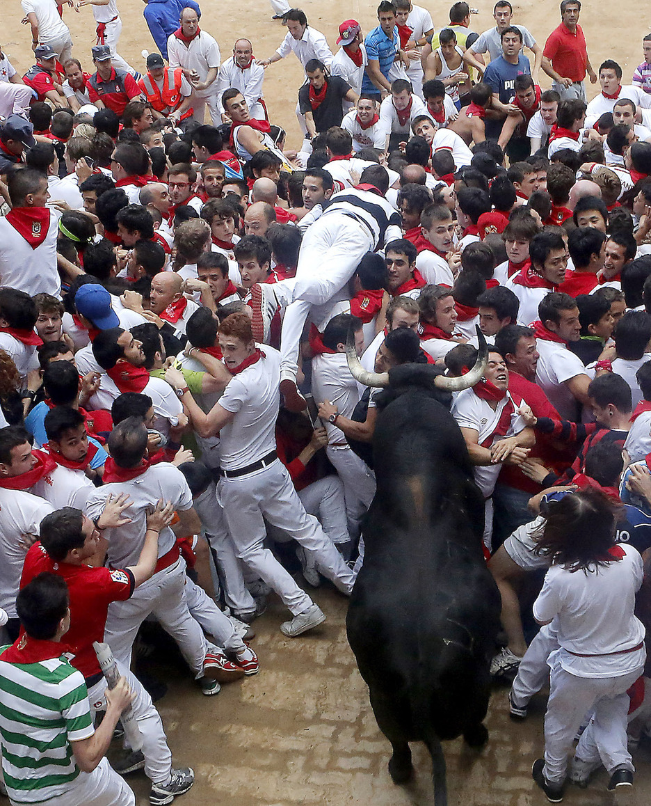 Un toro chocando contra el tapón humano.