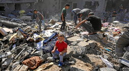 Un niño, sentado entre las ruinas de la vivienda de la familia Harb en Bujeirat, bombardeada por Israel durante la noche.