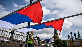 Un trabajador coloca unas banderas rusas para un evento celebrado en Moscú. 