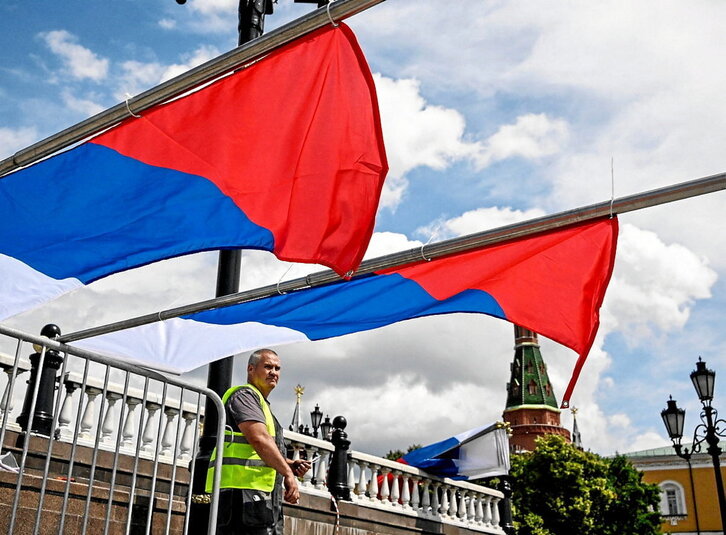 Un trabajador coloca unas banderas rusas para un evento celebrado en Moscú.