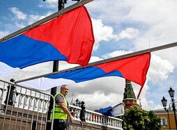 Un trabajador coloca unas banderas rusas para un evento celebrado en Moscú.