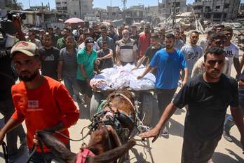 Gazatíes trasladan a varios de los muertos en los bombardeos israelíes contra un campo de refugiados de la capital del enclave. 