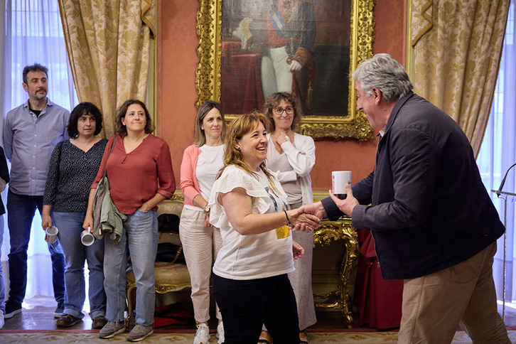 Joseba Asiron entrega una de las tazas a una de las mujeres reconocidas por su labor de acompañamiento a las víctimas de agresiones sexistas.