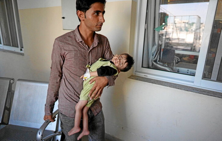 Un padre lleva a un niño al hospital Nasser, en Jan Yunis, que atiende niños con enfermedades por malnutrición y cáncer.