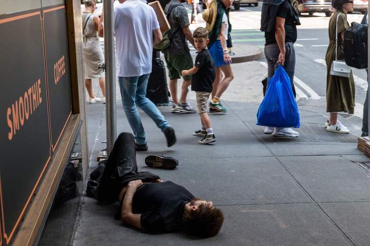 Una persona con problemas de adicción yace en el suelo cerca de una terminal de autobuses de Nueva York.