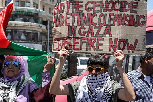 Una mujer sostiene en Ramallah una pancarta en la que pide el fin del «genocidio» y un alto el fuego en Gaza.