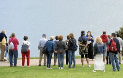 Un grupo de turistas atiende a su guía en Donostia.