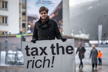 La austriaca Marlene Engelhorn, heredera del gigante químico alemán BASF, posa con un cartel que dice "Impuestos a los ricos" en elForo Económico Mundial WEF de Davos