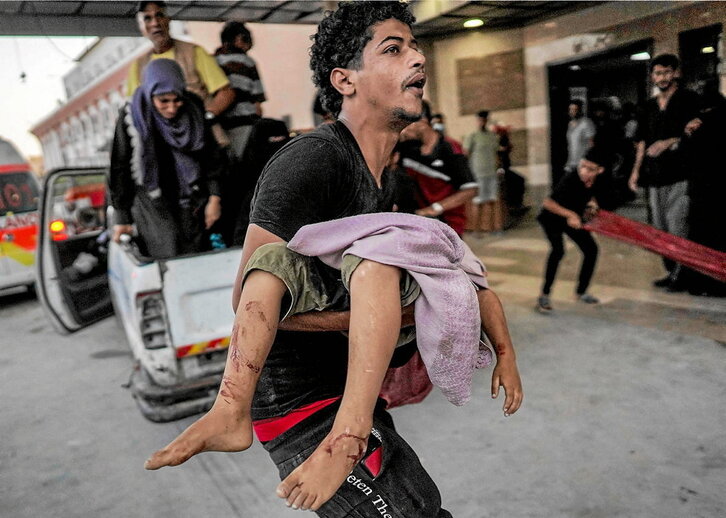 Un hombre lleva el cuerpo de un niño al hospital Nasser de Jan Yunis.