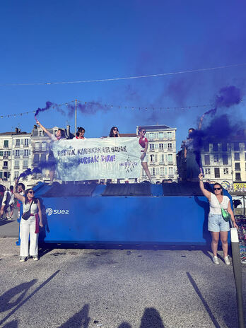 Jóvenes del grupo Ihurtzuri durante una acción contra la violencia machista en el arranque de fiestas de Baiona.