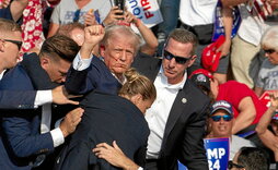 Donald Trump alza el puño mientras el Servicio Secreto lo protege, tras resultar herido en el mitin de Butler.