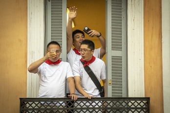 Turistas ven un encierro desde el balcón de una vivienda, en sanfermines de 2023.