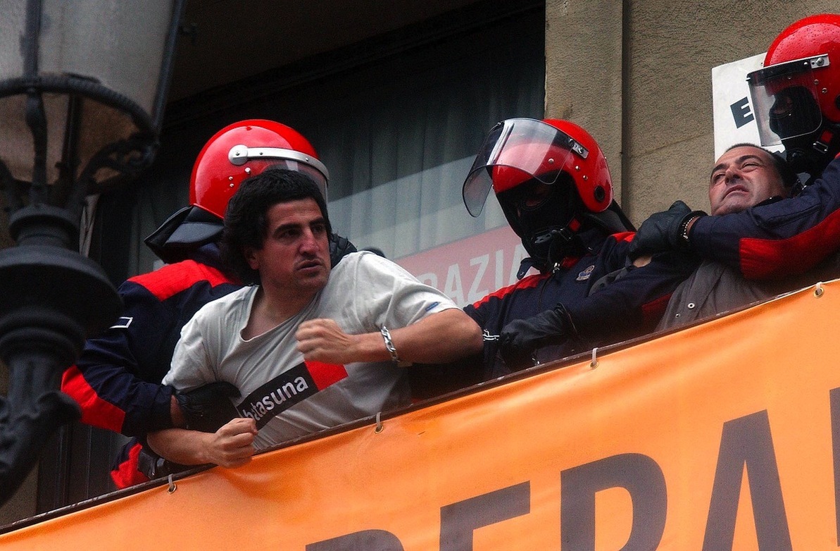 Agentes encapuchados forcejean con el edil Ibon Arbulu y el ex mahaikide Karmelo Landa en el balcón de la sede de Bilbo.