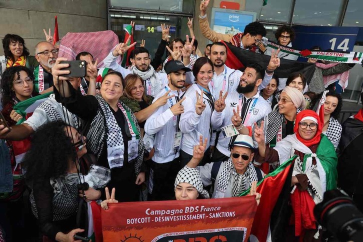 Algunos atletas de la delegación palestina posan con aficionados a su llegada al aeropuerto Charles-de-Gaulle. 
