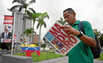 Un hombre lee en un diario en Caracas el resultado de las elecciones venezolanas.