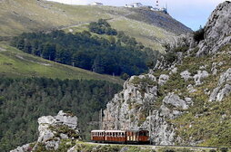 Argazki nagusian, aurten 100 urte bete dituen trena. Goiko argazkietan: mendizale bat pottoka bati begira, uda garaian sortzen den masifikazioaren irudia, eta tontorretik goza daitekeen ikuspegia.